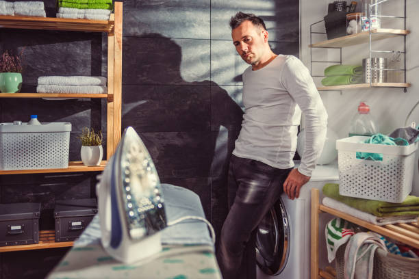 istock Man waiting for laundry at home 942024030