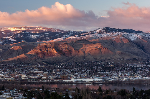 A view of downtown Wenatchee, Washington at sunrise in early march with the Columbia River and Saddle Rock visible