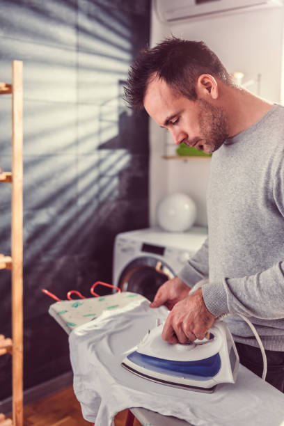 istock Men ironing shirt at laundry room 942024494