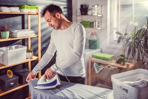 istock Men ironing clothes at home 942029218