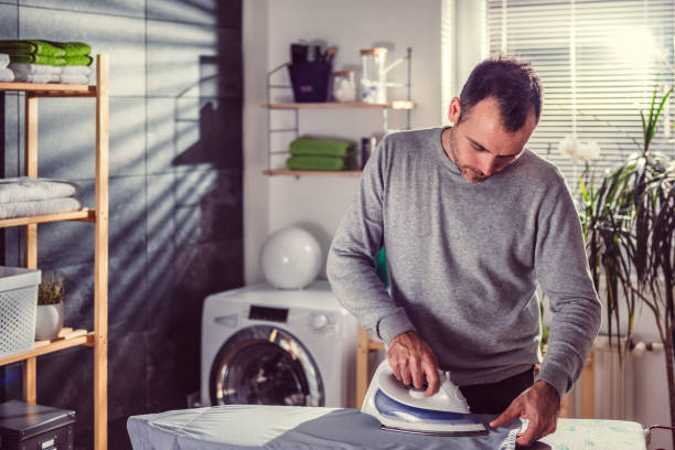 istock Men ironing clothes at home 942029718