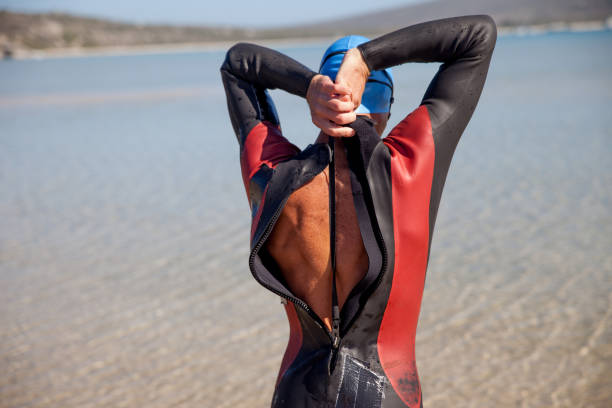 Young man pulling the zipper of a triathlon race suit
