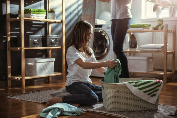 istock Daughter helping mother at laundry room 942106918