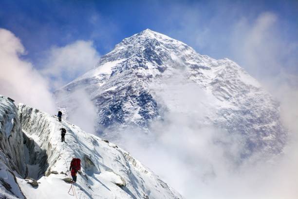 mount everest mit gruppe von bergsteigern - himalajagebirge stock-fotos und bilder