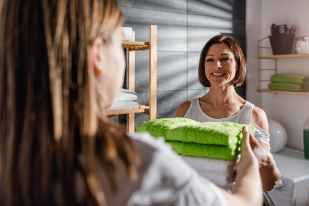 istock Daughter giving mother green folded towels 942114354