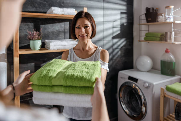 istock Daughter giving mother green folded towels 942115108