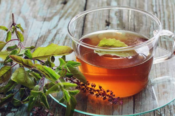 istock Tulsi Tea served in a cup with fresh leaves on the side, selective focus 942117148