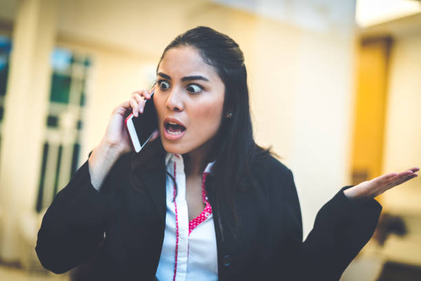 mujer de negocios hablando con su teléfono móvil - businesswoman frustration rudeness business fotografías e imágenes de stock