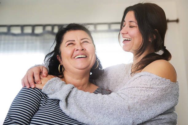 Positive senior mother and her daughter embracing stock photo