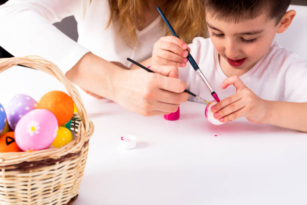 istock Mum and her son are painting egg 942120324
