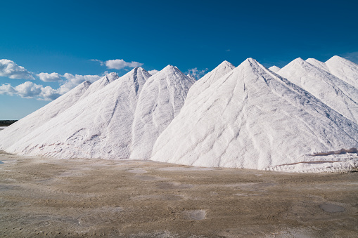 Large piles of sea salt under blue summer sky close to Salinas d'Es Trenc, South East Mallorca Island, Balearic Islands, Catalonia, Spain