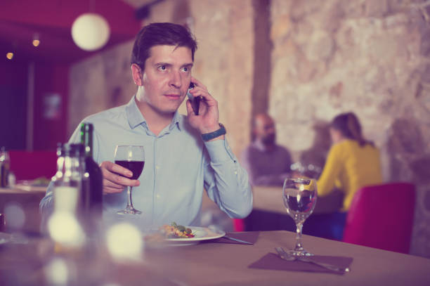 istock Young man talking on phone during evening meal 942130218