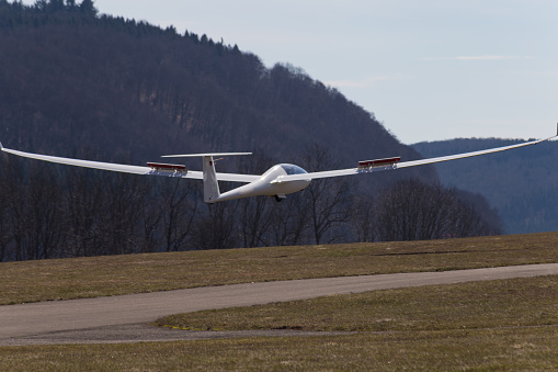 sailplane glider on south germany airfield with green grass and blue sky sunny easter springtime day