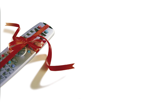 Remote control with red ribbon on white background