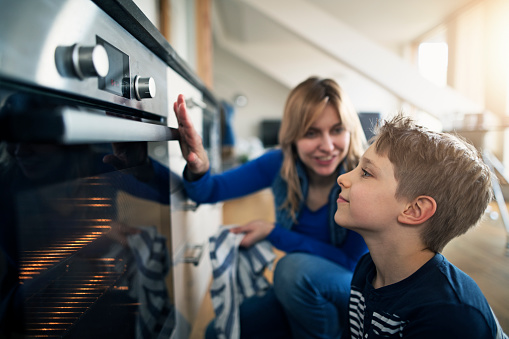 Mother explaining oven to her son.