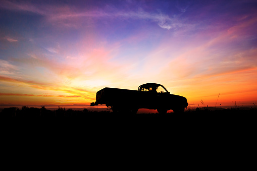 Silhouette of pickup truck on the background of beautiful sunset