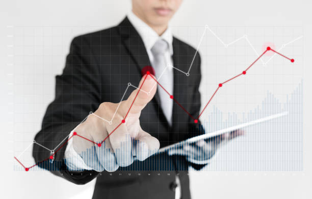 istock Businessman using digital tablet and pointing finger on graph diagram. Break even point, business growth, investment and finance concept 942142042