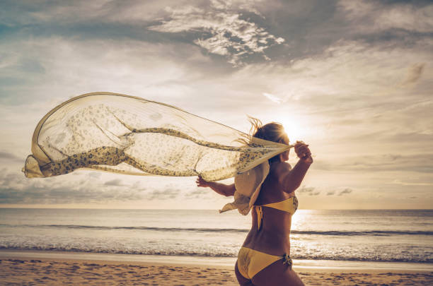 istock Woman feeling free while running with a shawl on the beach. 942144776