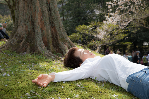 Japanese woman lie down on grass