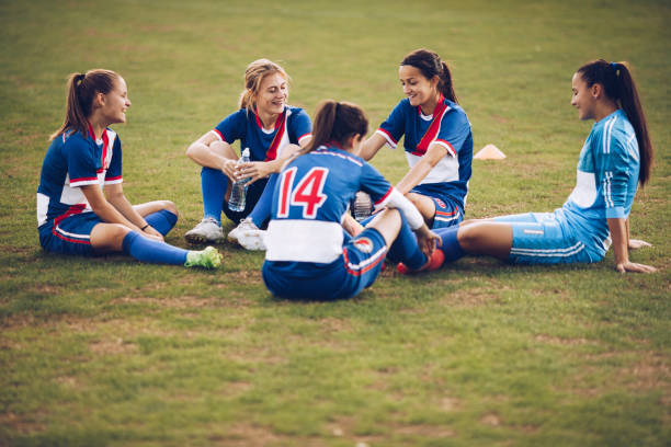 istock Teenage soccer team relaxing on grass and communicating. 942148416