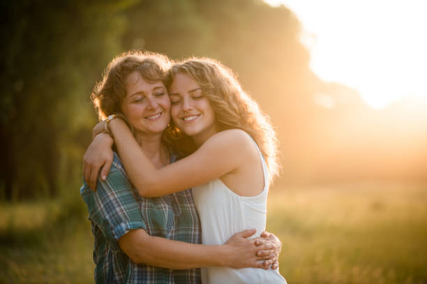 Daughter hugging mother stock photo