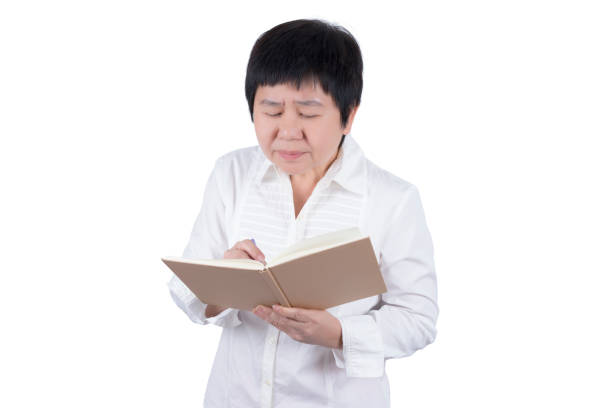 istock Asian Middle-aged woman in white shirt having vision problems in writing or reading isolated on white background , eyesight concept 942150882