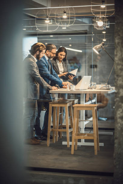 istock Group of business people cooperating while working on blueprints in the office. 942151028