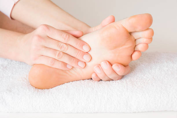 el hombre acostado y recibiendo tratamiento en centro de salud. manos del masajista haciendo masaje en los pies del hombre joven, cansado. relajarse y descansar de día. servicio de atención profesional. concepto de salud. - podiatrist customer service beauty spa fotografías e imágenes de stock