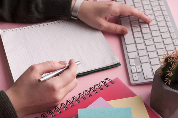 istock Woman's hands holding pen and spiral notepad 942151424
