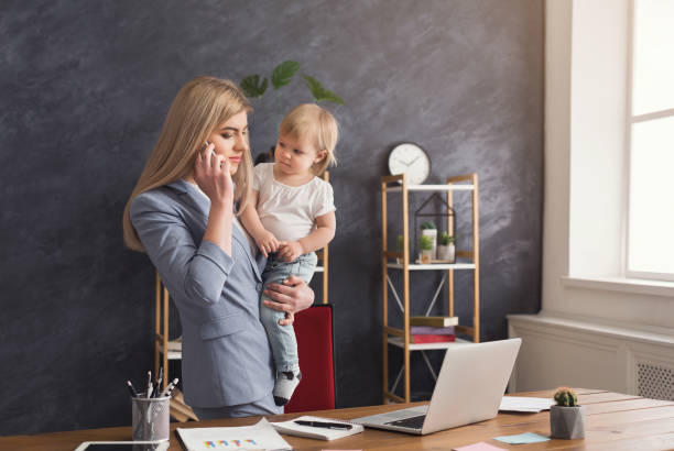 istock Young mother holding baby while talking on phone 942152138