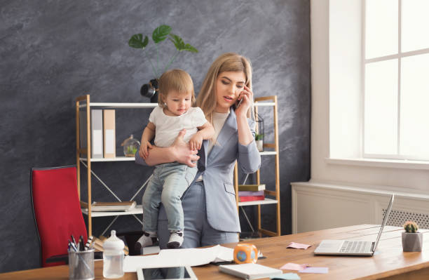 istock Young mother holding baby while talking on phone 942152468