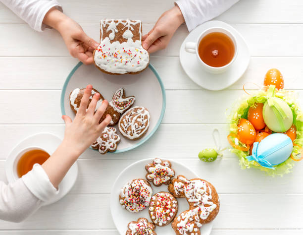 Children's hands taking cookies from table