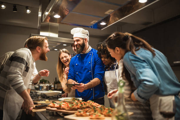 istock Chef and attendees of cooking class browsing photos on mobile phone 942153866