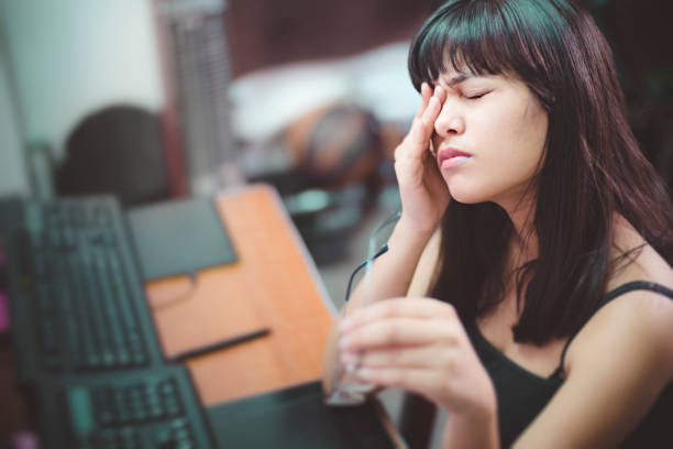 Young woman with aching eyes after working on computer. stock photo