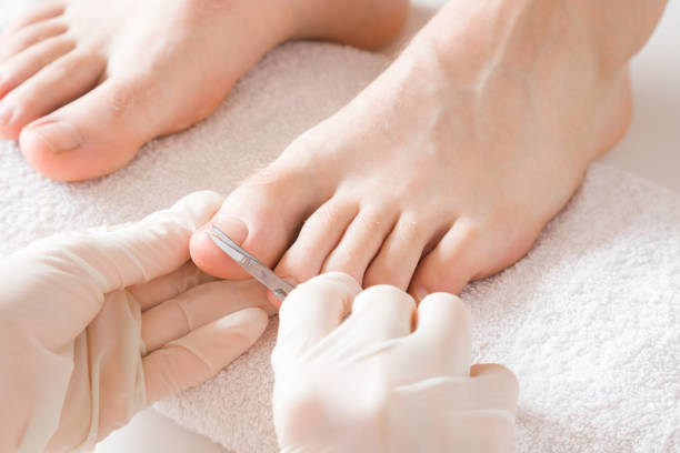 Pedicurist's hands in protective rubber gloves cutting toenails with scissors. Cares about man's feet. Specialist with client in beauty salon. Professional beauty service. Pedicure, manicure concept. Pedicurist's hands in protective rubber gloves cutting toenails with scissors. Cares about man's feet. Specialist with client in beauty salon. Professional beauty service. Pedicure, manicure concept. toenail stock pictures, royalty-free photos & images
