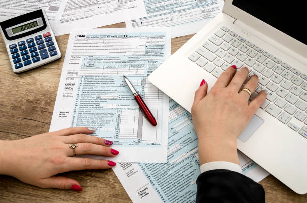 istock Tax form 1040 human hands and laptop 942154926