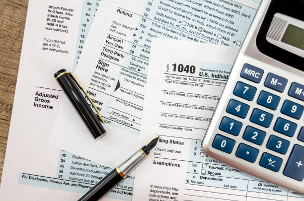 istock Calculator and pen with 1040 tax form 942156322