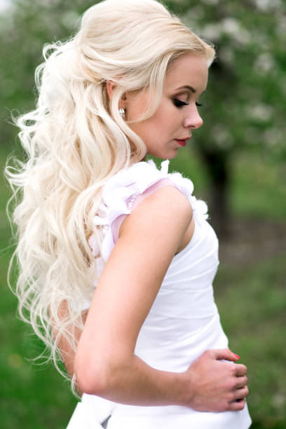 istock young pretty bride with curls n white wedding dress outdoors, view from behind 942156438