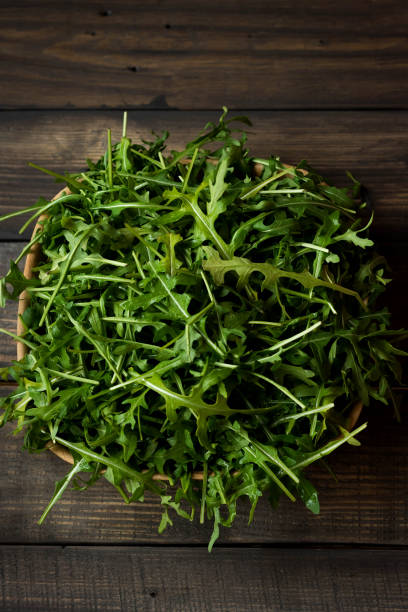 istock Fresh rucola with water droplets on a dark rustic background 942157298