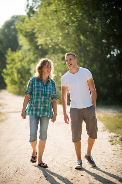 Son spending priceless time with his mother as they walk together stock photo