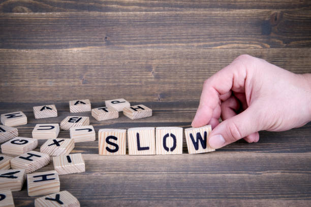 istock Slow. Wooden letters on the office desk 942159152