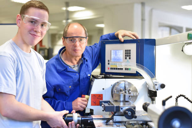 istock portrait apprentice and teacher in vocational training at a cnc lathe 942163750