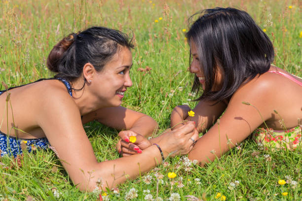 kids girls sharing icecream on each other on the field of meadow
