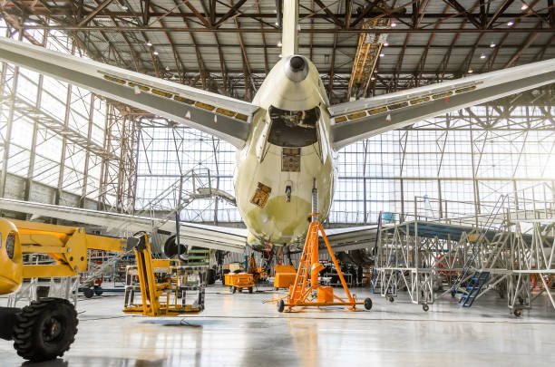 Passenger aircraft on service in an aviation hangar rear view of the tail, on the auxiliary power unit. Passenger aircraft on service in an aviation hangar rear view of the tail, on the auxiliary power unit airplane maintenance stock pictures, royalty-free photos & images