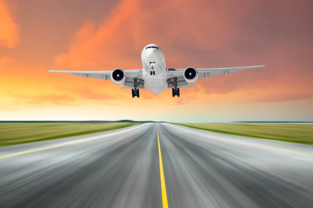 istock Airplane flying deperture landing speed motion on a runway in the evening during a bright red sunset. 942165730