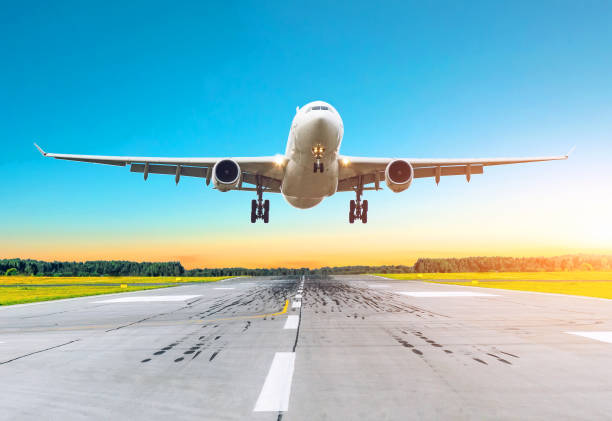 istock Airplane flying arrives landing on a runway in the evening. 942165838