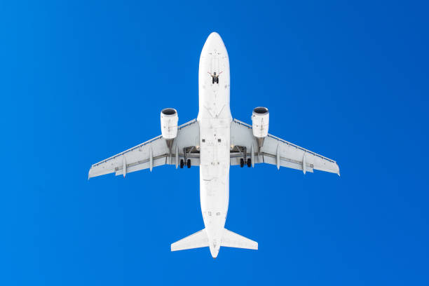 istock Passenger airplane. View exactly from below, silhouette against the blue sky. 942166104