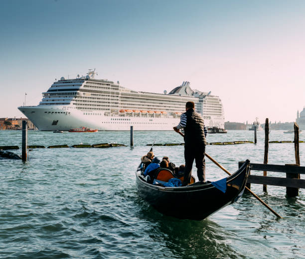 justaposição de gôndola e enorme cruzeiro no canal giudecca. transporte novo e antigo na lagoa de veneza - lagoa veneziana - fotografias e filmes do acervo