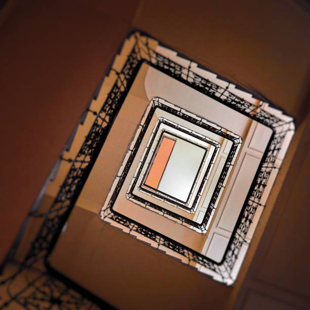 Image of a multilevel multicolored staircase in an old building with grey straight square stairs green sides and yellow floors