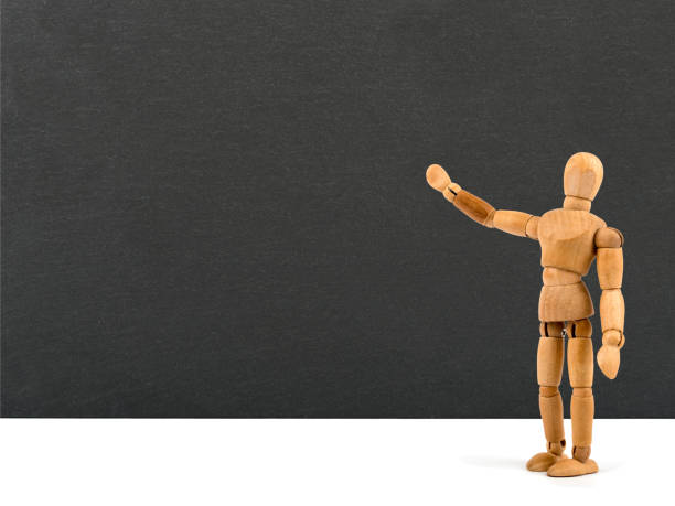 Wooden mannequin showing something on chalkboard - add your own text
